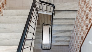 A marble staircase with a metal handrail and a metal basket. - Holiday Home 'Linda' with Private Terrace, Wi-Fi and Air Conditioning (Olhão)