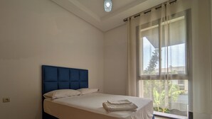 A bedroom with a bed, a window with curtains, and a ceiling light. - Lovely 3-bedroom villa with Private  Pool in Tamaris (Tamaris)