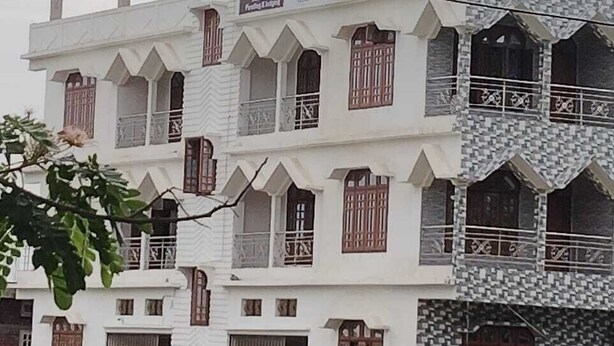 A multi-story building with a white facade and multiple balconies.