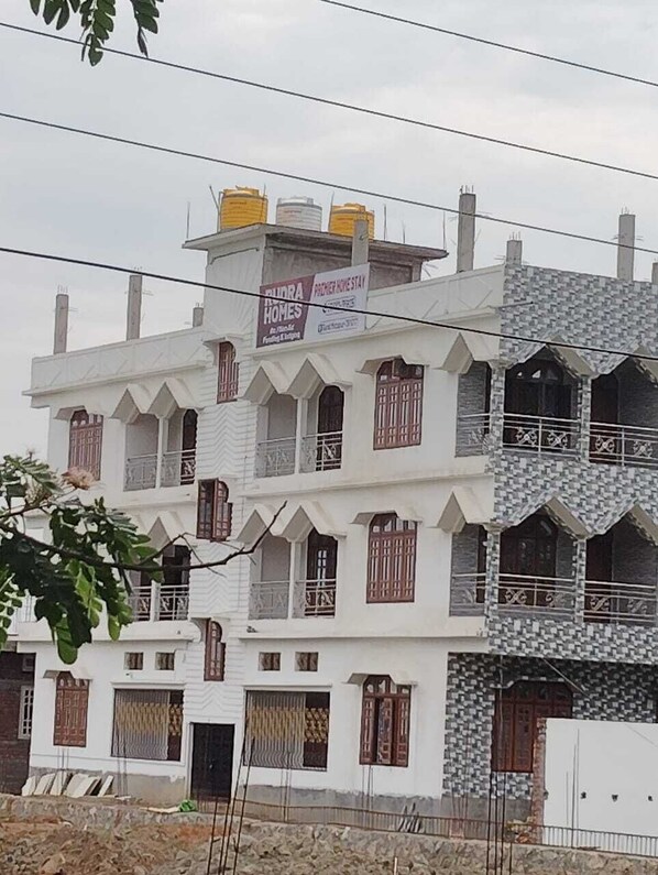 A multi-story building with a white facade and multiple balconies.