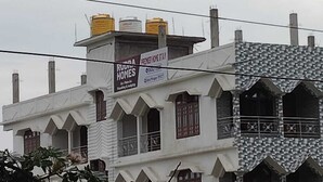 A building with a sign for 'Rudra Homes' advertising 'Premier Home Stay.'