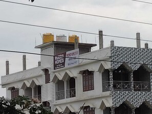 A building with a sign for 'Rudra Homes' advertising 'Premier Home Stay.'