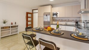 A modern kitchen with a central island, a refrigerator, microwave, and a sink. - Holiday Apartment 'Rolycar 101' with Private Terrace and Wi-Fi (Icod de los Vinos)