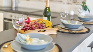 A kitchen counter with a bottle of champagne, a bowl of fruit, and a plate of food. - Holiday Apartment 'Rolycar 101' with Private Terrace and Wi-Fi (Icod de los Vinos)