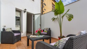 A patio with wicker furniture, a potted plant, and a door leading to an interior space. - Holiday Apartment 'Rolycar 101' with Private Terrace and Wi-Fi (Icod de los Vinos)