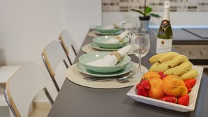 A dining table set with plates, cutlery, a bottle of wine, and a bowl of fruit. - Holiday Apartment 'Rolycar 102' with Wi-Fi (Icod de los Vinos)