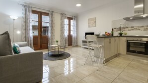 A modern kitchen with a dining area, a sofa, and a small table with a plant. - Holiday Apartment 'Rolycar 204' with Wi-Fi (Icod de los Vinos)