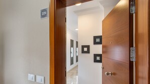 A hallway with a wooden door, a number sign, and framed pictures on the wall. - Holiday Apartment 'Rolycar 204' with Wi-Fi (Icod de los Vinos)
