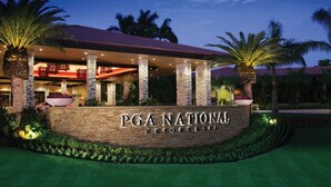 PGA National Resort & Spa -hotellissa on katettu ulkoalue, kivipylväitä ja palmuja.