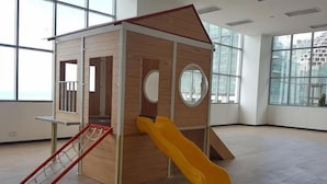 A play structure with a slide and climbing area in a room with large windows and wooden flooring. - Mykey Silverscape B-39-07 Melaka City (Melaka)