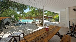 An outdoor patio with a wooden table, chairs, a hot tub, and a swimming pool. - Austin's Hill Country Escape & Retreat – Private Oasis With Pool & Spa on Acre+ (Austin)