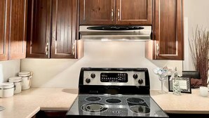 A kitchen with wooden cabinets, a stainless steel stove, and a white countertop.