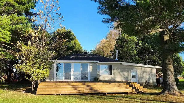 A single-story house with a front porch, a small deck, and a well-maintained lawn.