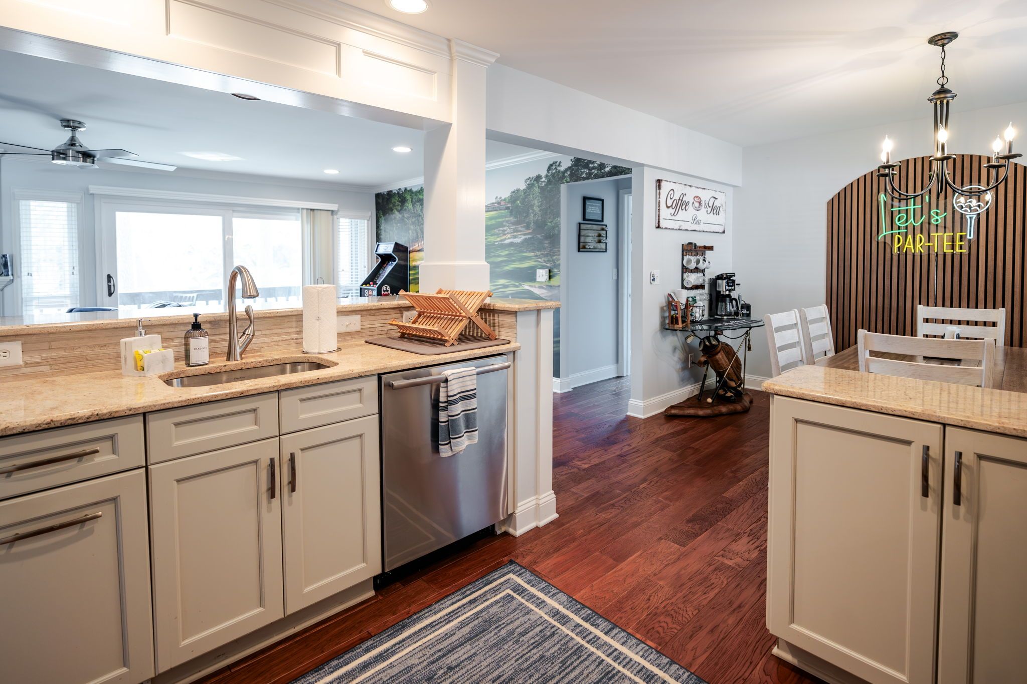 A modern kitchen with a central island, a coffee station, and a dining area with a wooden table and chairs.