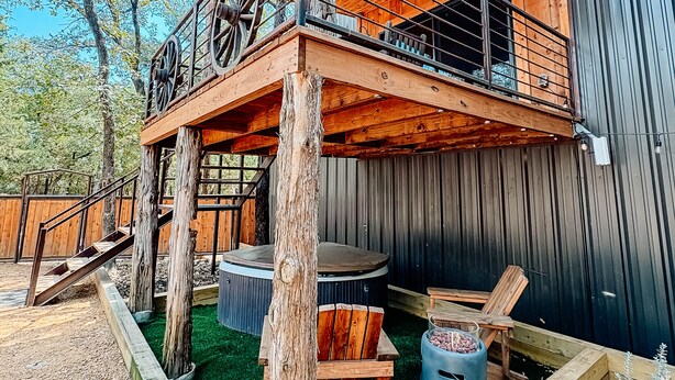 A wooden cabin with a balcony, a hot tub, and a wooden deck. - Bison Suite - relax in your private hot tub and explore the Ranch!  (Valley View)