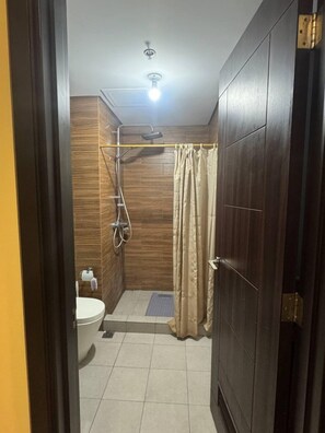 Ein kleines Badezimmer mit Dusche, Toilette und Handtuchhalter.