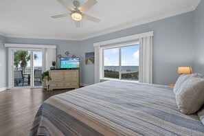 A bedroom with a large bed, a ceiling fan, a television, and a view of the ocean. - Palm Beach D-21  Great Views (Orange Beach)