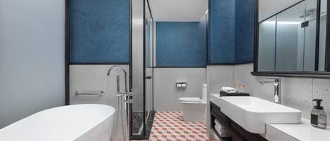 A modern bathroom with a bathtub, a shower, and a sink.