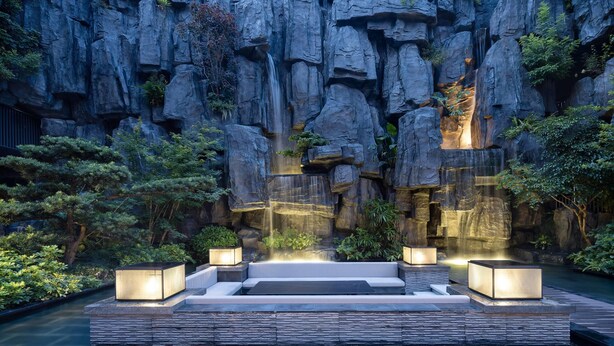 A rock garden with a waterfall, seating area, and illuminated planters. - Wyndham Grand Shenzhen Guangming (Shenzhen)