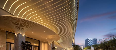 A modern building with a curved roof and illuminated lines.