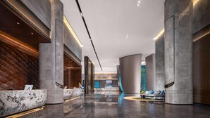 A modern lobby with marble reception desks, high ceilings, and a sleek, curved design. - Wyndham Grand Shenzhen Guangming (Shenzhen)