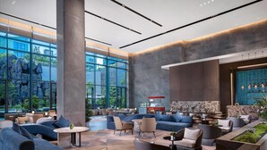 A spacious lobby with large windows, a reception area, and modern seating arrangements. - Wyndham Grand Shenzhen Guangming (Shenzhen)