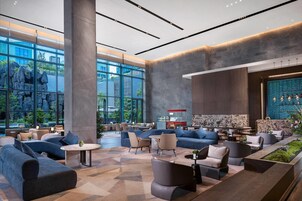 A spacious lobby with large windows, a reception area, and modern seating arrangements.