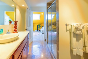 A bathroom with a sink, mirror, and towel rack. - Tropical Lotus- Cozy 3 bedroom, 3 bath with an ocean view, pool, gym, & tennis (St Thomas)