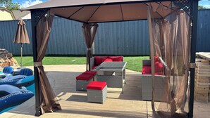 An outdoor patio with a covered seating area, wicker furniture, and a pool. - Ultimate Game Day Stay, 3BR House +Pool Near AT&T Stadium but far from the noise (Arlington)