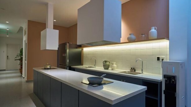 A modern kitchen with a central island, a built-in oven, and a stainless steel refrigerator. - Express by M Village Cach Mang Thang 8, a brand of Modern Village Lifestyle (Ho Chi Minh City)
