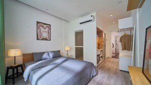 A modern bedroom with a large bed, bedside tables, a wardrobe, and a walk-in closet. - Express by M Village Cach Mang Thang 8, a brand of Modern Village Lifestyle (Ho Chi Minh City)