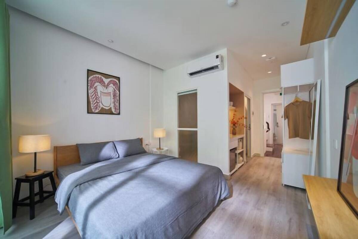 Ein modernes Schlafzimmer mit einem großen Bett, Nachttischen, einem Kleiderschrank und einem begehbaren Kleiderschrank.