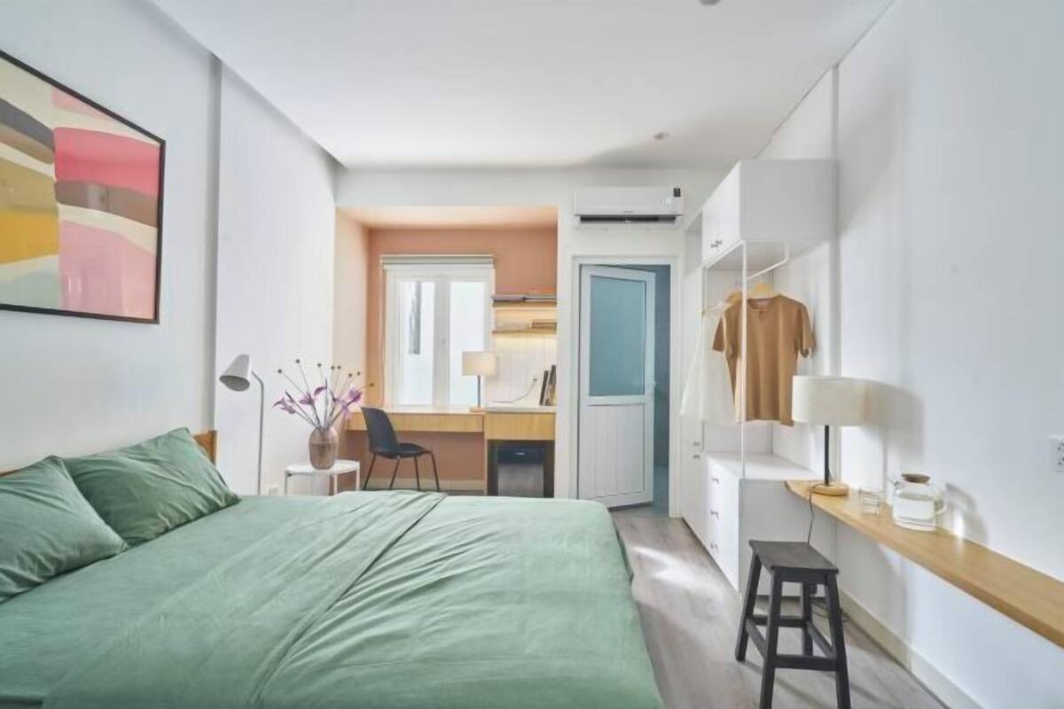 Ein modernes Schlafzimmer mit Bett, Schreibtisch und Kleiderschrank.