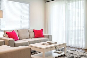 Casa de ciudad, 1 cama Queen size, patio, vista al jardín (148 A, Irvine-2) | Área de sala de estar | Televisión de pantalla plana de 42 pulgadas con canales digitales 