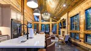 Interior moderno de uma cabana de toras, com cozinha, sala de jantar e sala de estar.