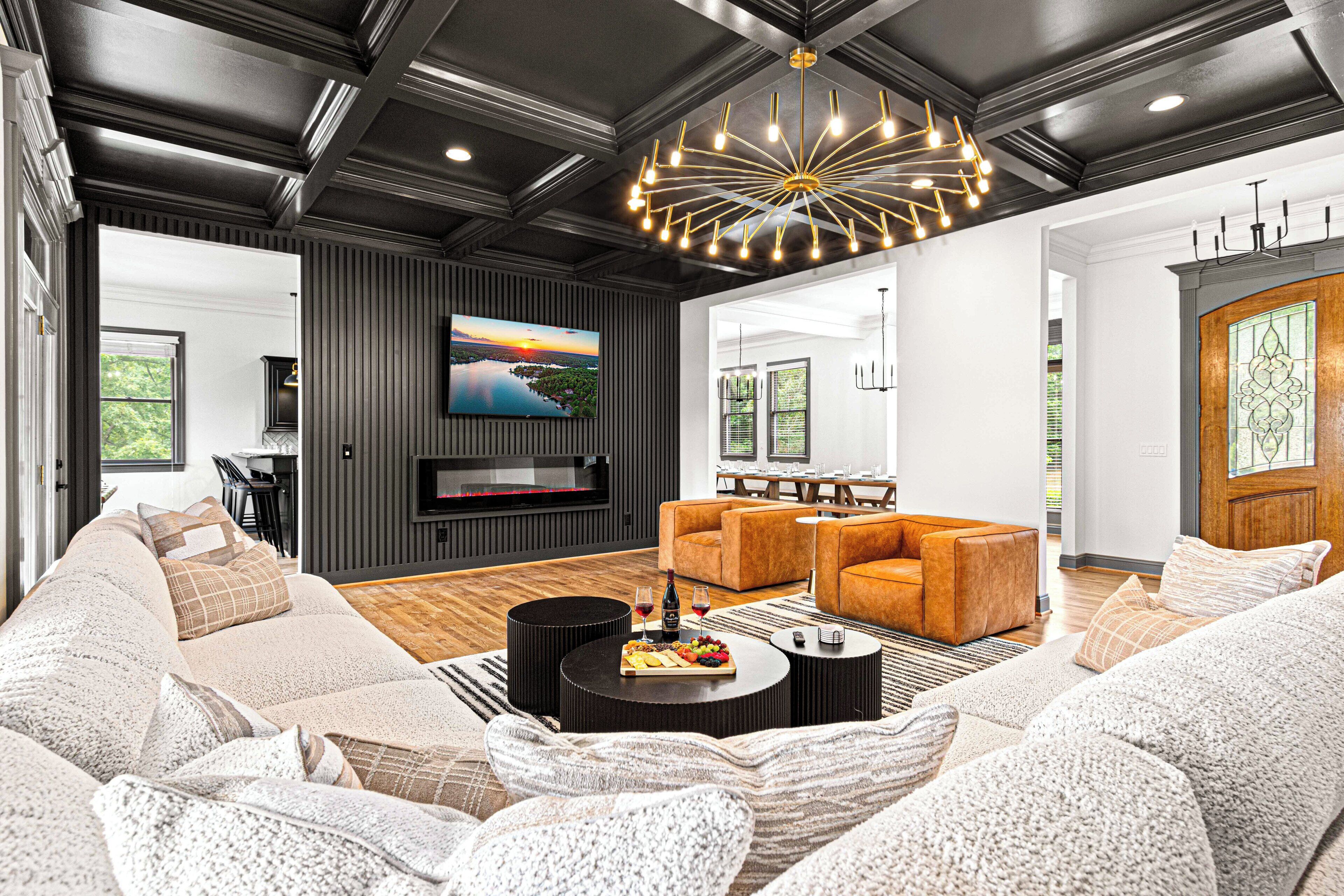 Un salon moderne avec un canapé d’angle, une cheminée et un grand téléviseur.