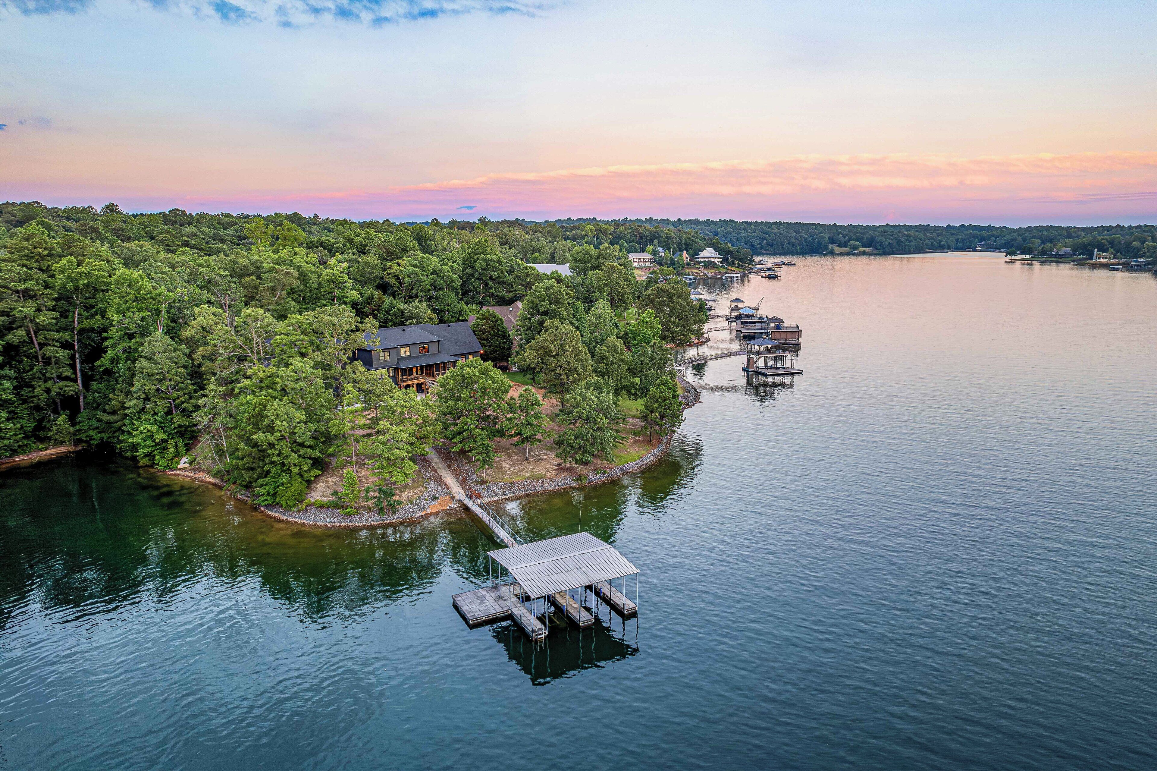 A lakeside property with a dock, a house, and a boat.