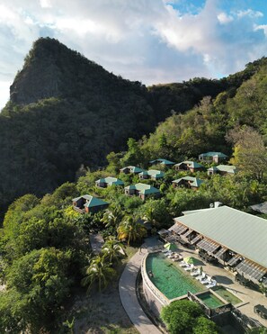 A resort with multiple buildings, a swimming pool, and lush greenery. - Jungle Bay Dominica (Soufriere)