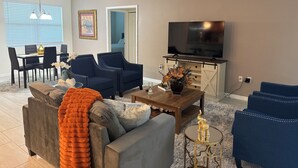 Una sala de estar con comedor, televisor y chimenea.