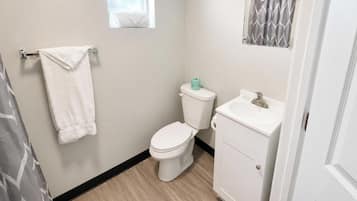 A bathroom with a toilet, sink, and towel rack.