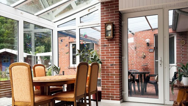 A dining area with a brick wall, a wooden table, and chairs. - Tammen's "Klönstuv" - stylish & cozy (Papenburg)