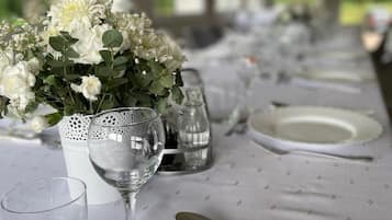 Une table mise pour un repas, avec des assiettes blanches, des couverts en argent et un verre d’eau.
