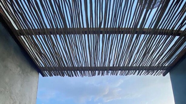 A pool with a view of mountains and greenery, a concrete structure, and a bamboo ceiling. - Batur Sunsun Kintamani By Zuzu (Kintamani)