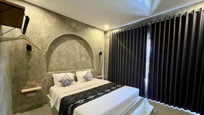 Een moderne slaapkamer met een groot bed, een hoofdeinde, een nachtkastje en een raam met gordijnen.