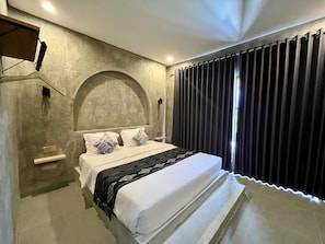 Une chambre à coucher moderne avec un grand lit, une tête de lit, une table de chevet et une fenêtre avec des rideaux.