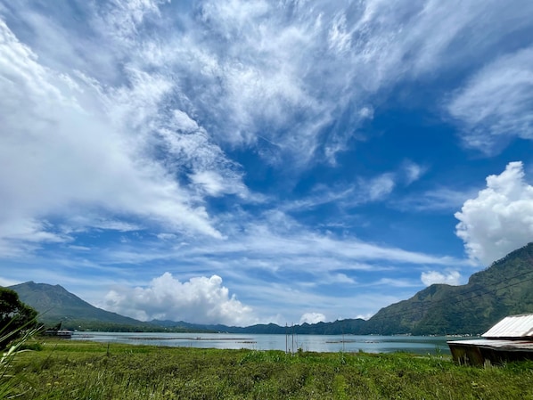 Un paysage montagneux, avec un ciel dégagé et une étendue d’eau.