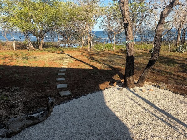 A pathway leading to a beach area with a sign indicating 'PLAYA'.