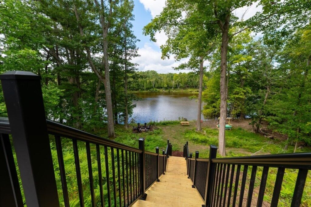 A wooden staircase leading to a lake surrounded by trees.