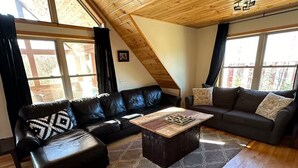 Ein Wohnzimmer mit Holzboden, zwei Sofas, einem Couchtisch und einem gemusterten Teppich.