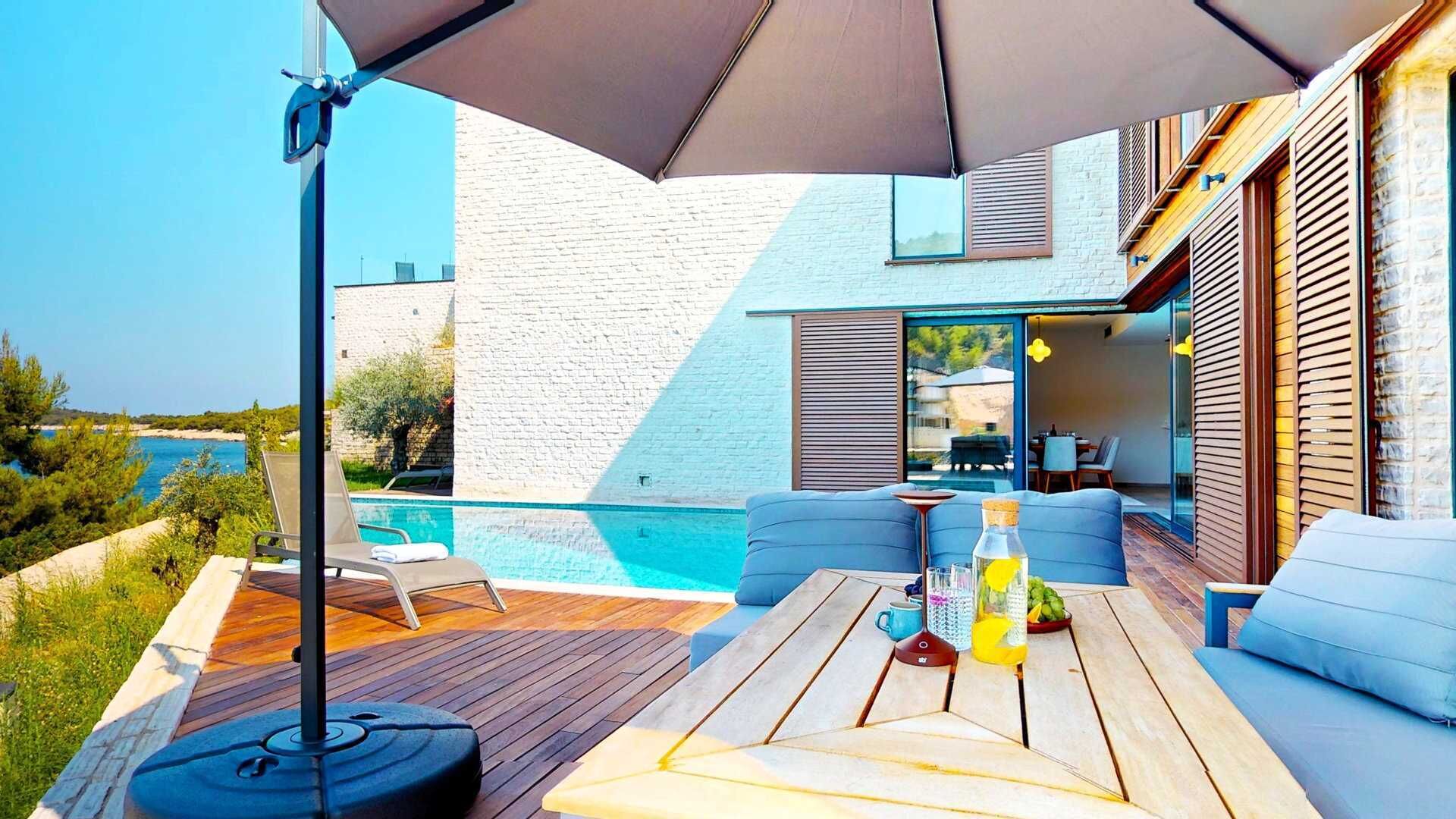 Terrassa exterior moderna amb piscina, terrassa de fusta i zona d'estar.